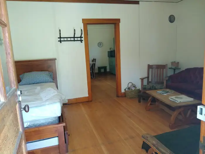 Atlanta Cabin β A living room with a bed, couch, futon, and table.