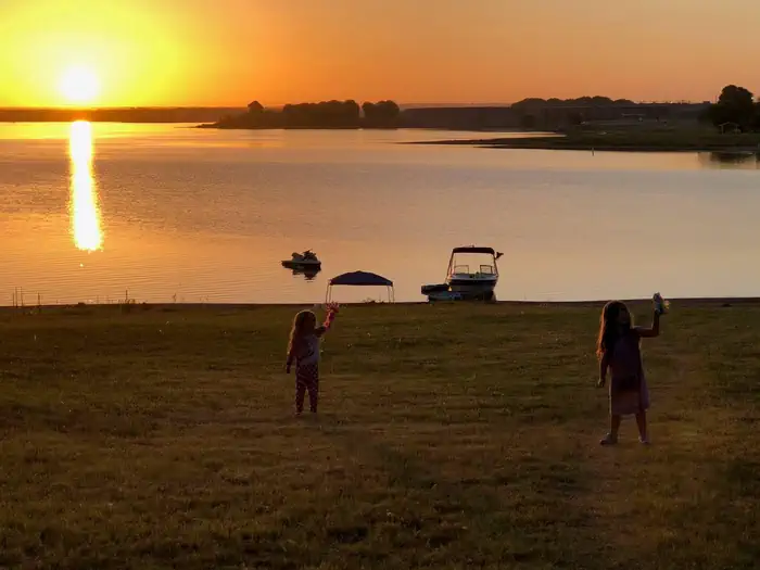 Copperas Creek — Two children stand near the shore of a lake at sunset