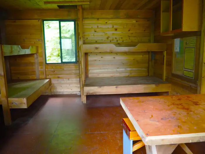 Frosty Bay Cabin — Frosty Bay Cabin, wooden interior of cabin with four bunks and a table
