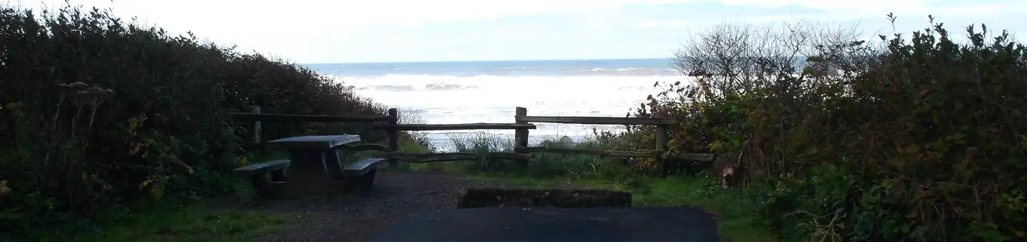 Kalaloch — A campsite on a bluff overlooking the Pacific Ocean. The campsite has a paved parking spot as well as a picnic table and fire ring.