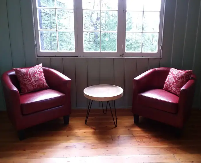 Post Creek Guard Station — Two red chairs and a coffee table in living room.