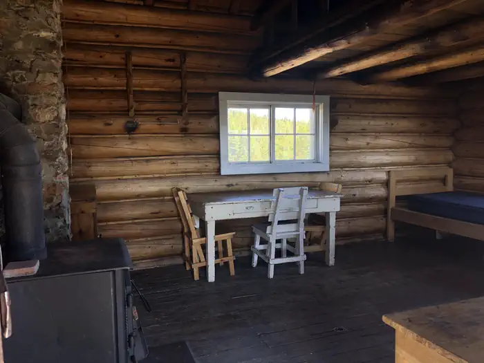 Little Bear Cabin — Wood burning stove and table with chairs