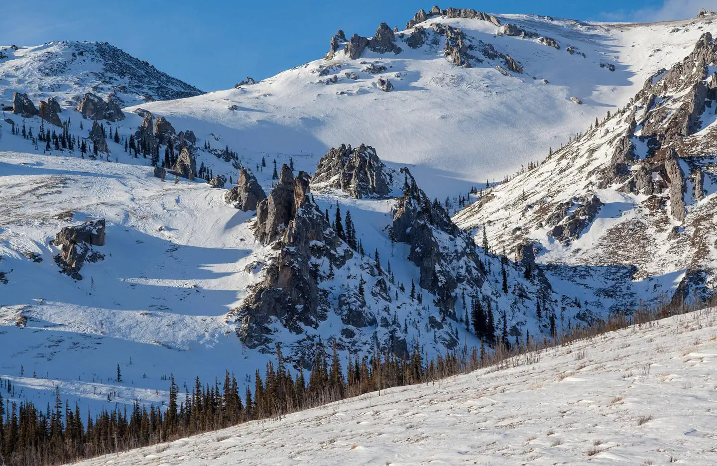 White Mountains National Recreation Area - Alaska Cabins — Rocky outcrops protrude from snow-covered mountains