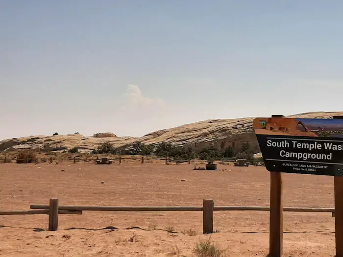 South Temple Wash Campground — Wide angle photo of campground with sign in foreground that says "South Temple Wash"