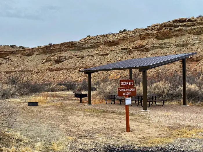 Westwater Group Site (ranger Station) — Westwater Group Site picnic tables underneath shade shelter and sign.