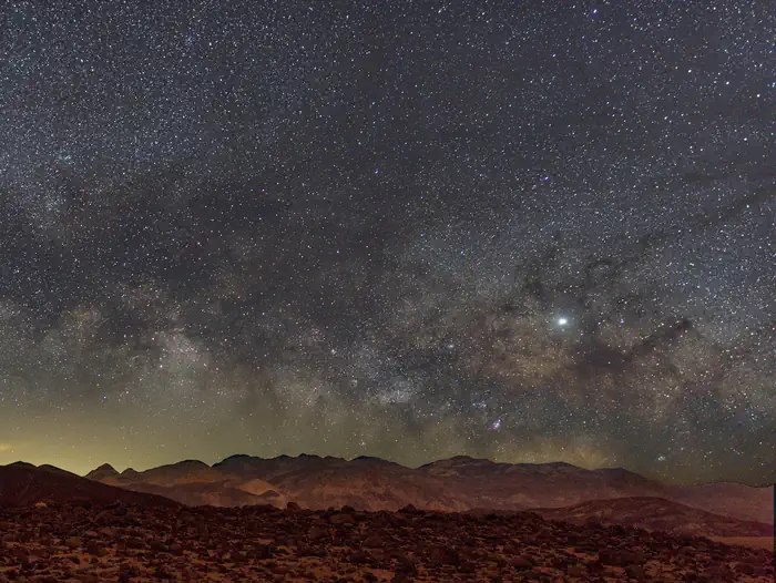 Furnace Creek Campground — Mountains in foreground, clear night sky filled with stars in background.