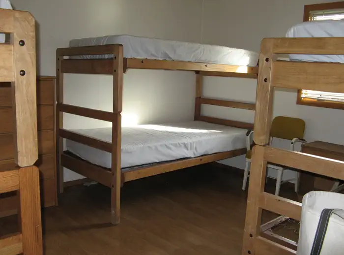 Calf Creek Cabin — Three sets of twin wooden bunk beds with mattresses in a bedroom