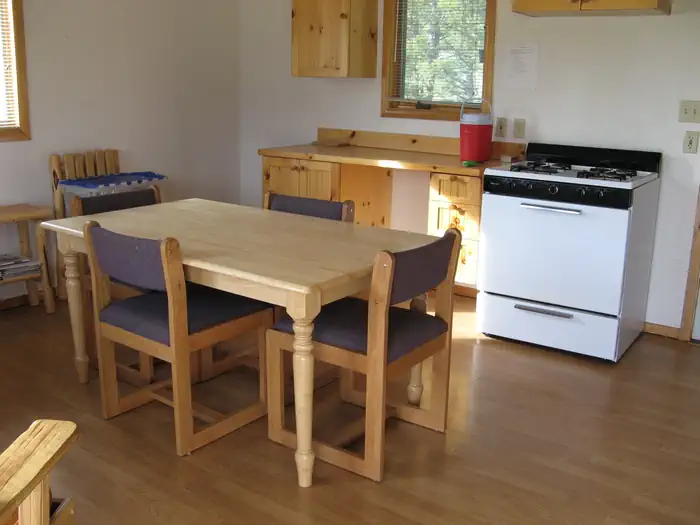 Calf Creek Cabin — A small wooden kitchen table and counters in a cabin