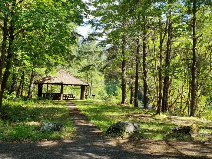 Canton Creek Campground — Group Picnic Shelter in sunlit glade of forested creek bank.