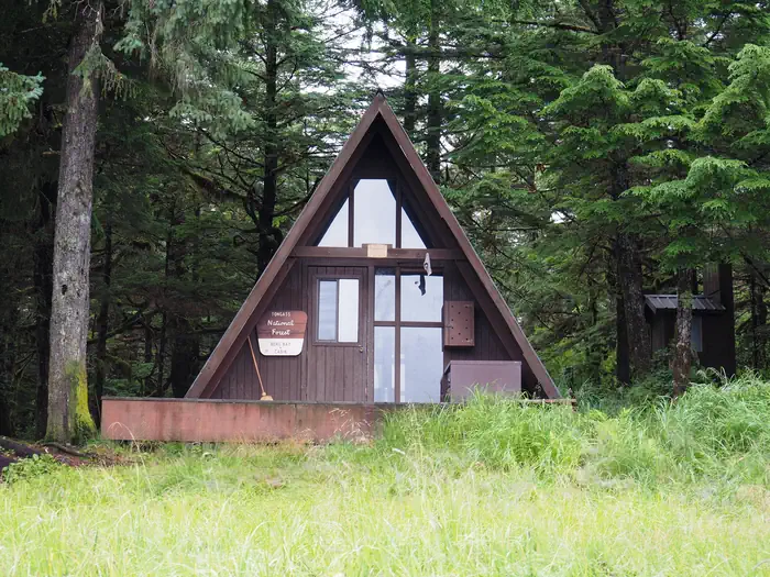 Berg Bay Cabin β Brown A-Frame Cabin with steps leading up to it and trees behind and beside it. Berg Bay Cabin