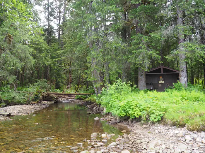Eagle Lake Cabin — Eagle Lake Cabin with stream on side surrounded by trees