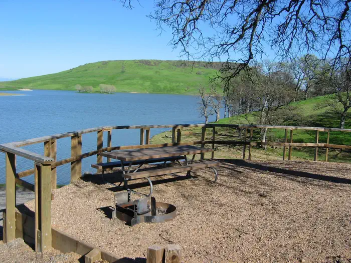 Buckhorn Recreation Area — Campsite within Buckhorn Campground showing picnic table, firepit, and lake in background.
