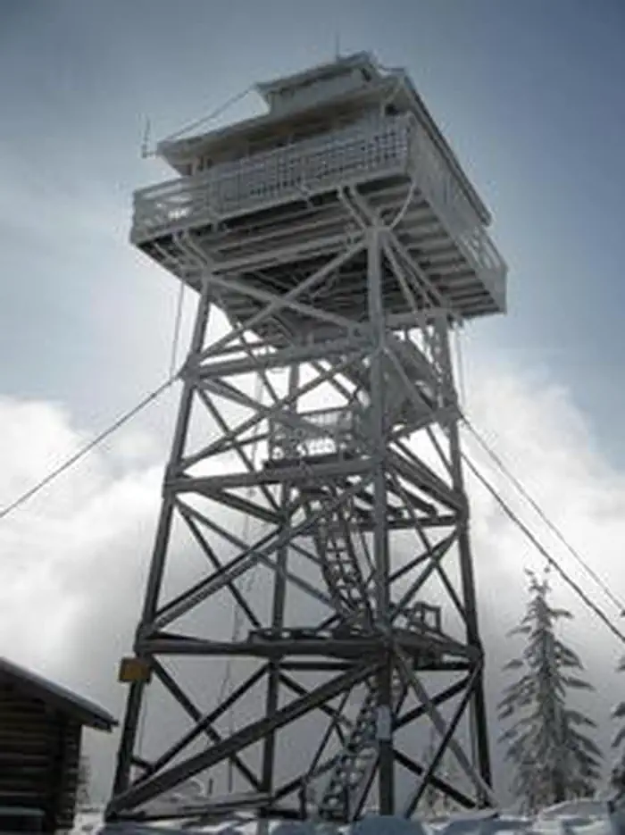 Warner Mountain Lookout β A tall lookout stands in the snow with stairs.