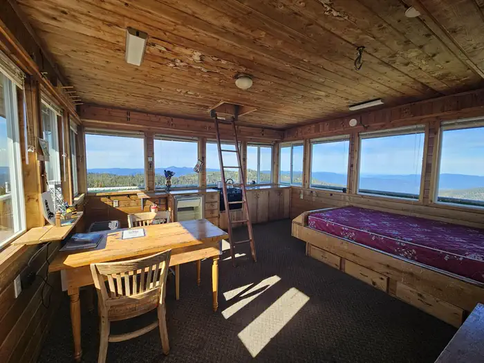 Warner Mountain Lookout β interior of a lookout, with bed, table and chair