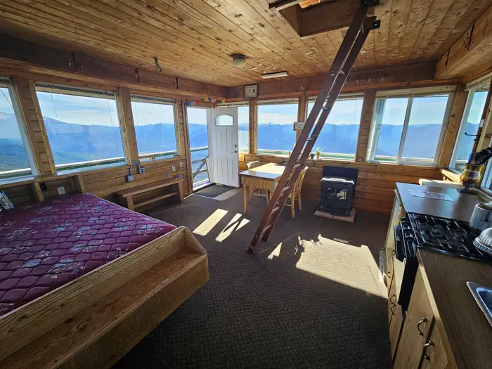 Warner Mountain Lookout β Interior of a lookout, with ladder, bed and stove