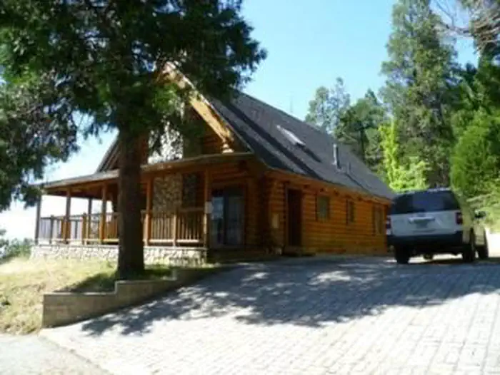 Grouse Valley — Exterior of the Hillside Cabin showing deck and parking area