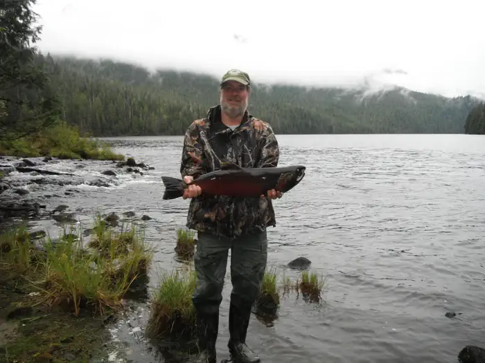Anan Lake Cabin — Fisherman holding coho salmon in front of Anan Lake