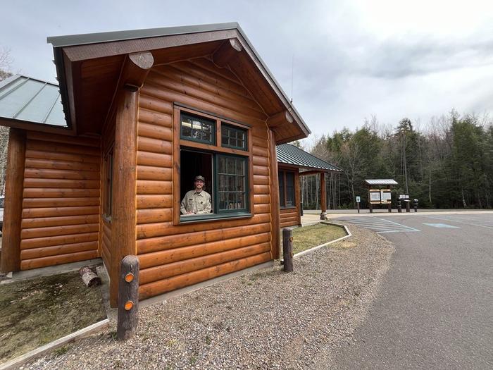 Sylvania Wilderness Backcountry Camping — A window is open on a log entrance station building with a staff member inside ready to greet visitors.