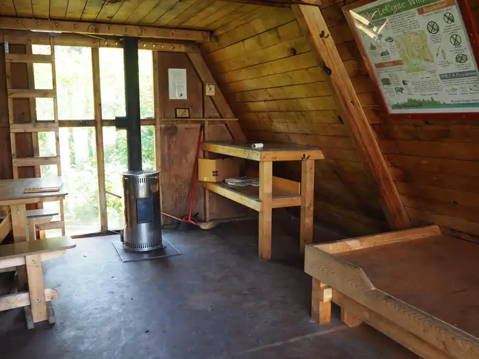 Shakes Slough 2 Cabin — Shakes Slough 2 Cabin interior showing wood bunk, table stove and vertical ladder to loft