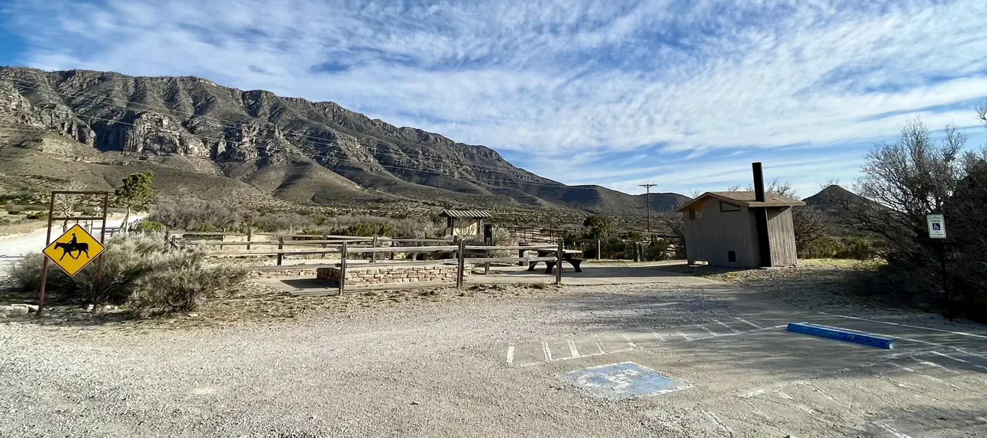 Frijole Horse Campground — Frijole Horse Corral Campsite with RV parking spaces in the foreground, tent pads, picnic table and restroom are shown.