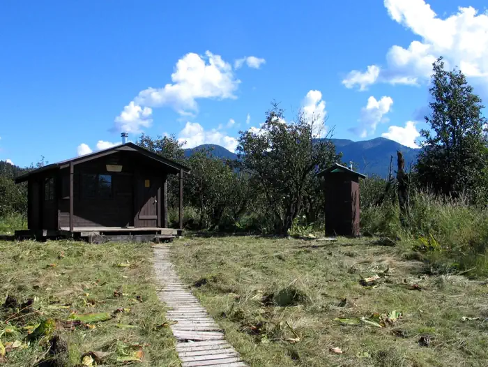 Koknuk Cabin — Koknuk Cabin with wooden trail leading to it and the outhouse