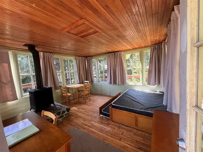 Timber Butte Cabin — Timber Butte Cabin stove, desk, and bed.