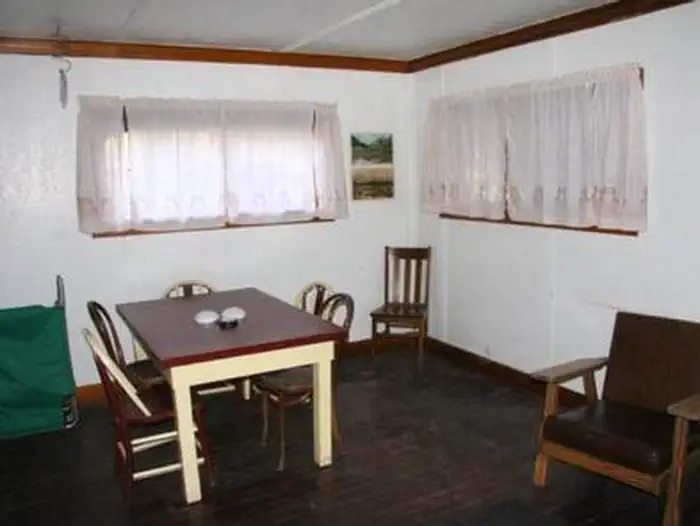 Big Trinity Cabin — Room with windows, tables, and chairs located in the middle