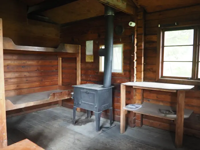 Sergief Island Cabin — Sergief Island Cabin interior showing wood bunkbeds, shelves and stove