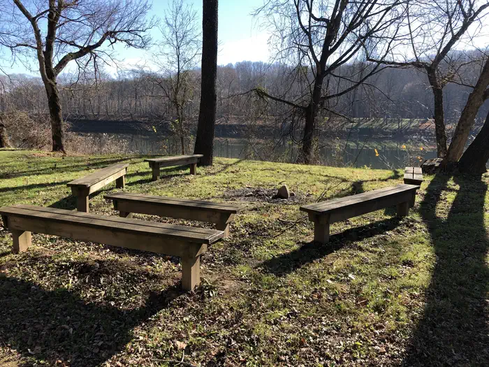 Mccoy's Ferry Campground — Wooden benches form a horseshoe at the campground's gathering area