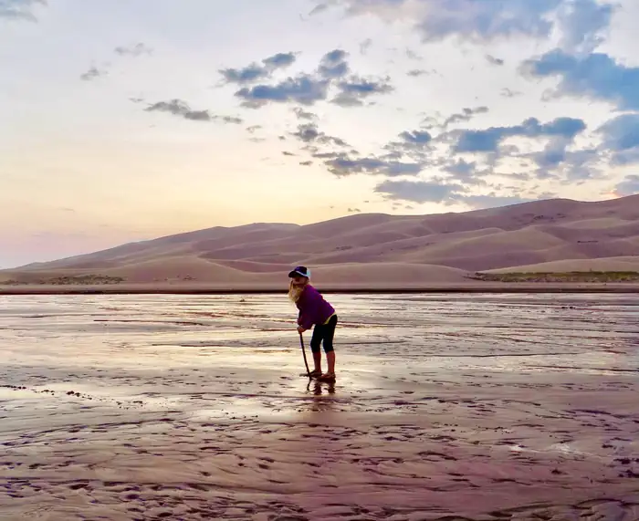 Pinon Flats Campground — Person poses in front of sand dunes.