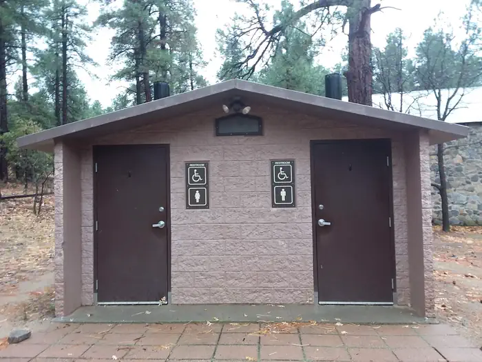 Groom Creek Schoolhouse β Accessible two vault toilet building with concrete slab in front located behind main building.