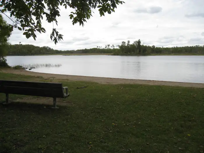 Fall Lake — Picture of beach and bench.