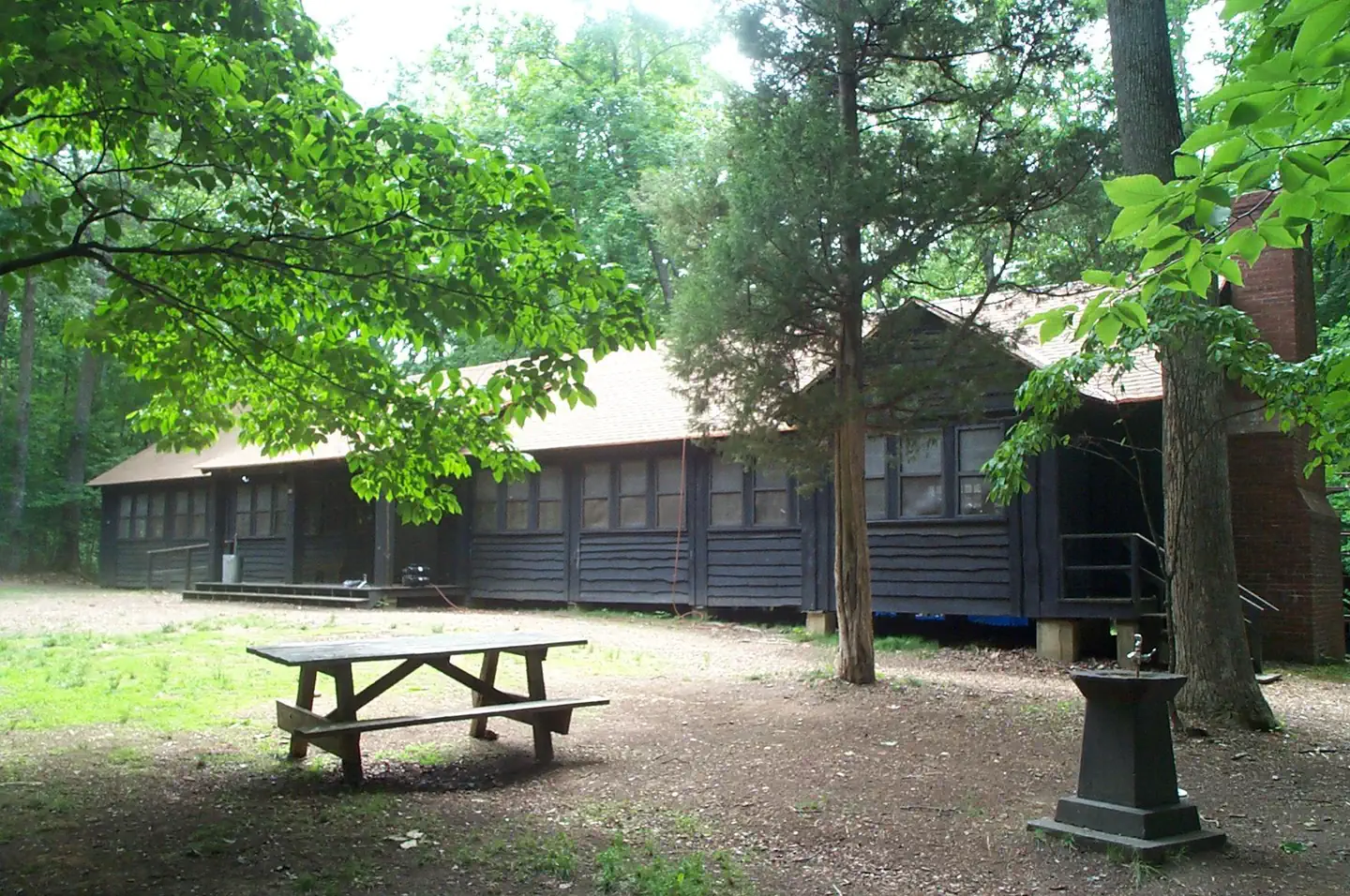 Cabin Camp 3 — A picnic table under the shade of trees on the grounds of Cabin Camp 3