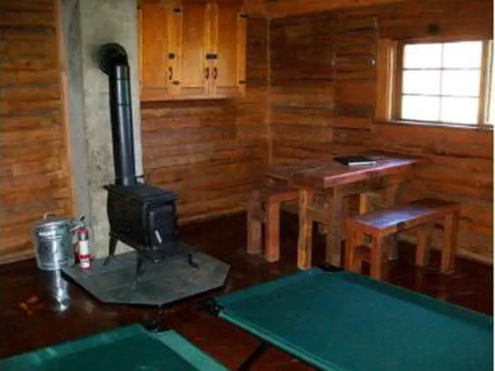 Piney Guard Station β A stove and other furniture inside a wooden cabin