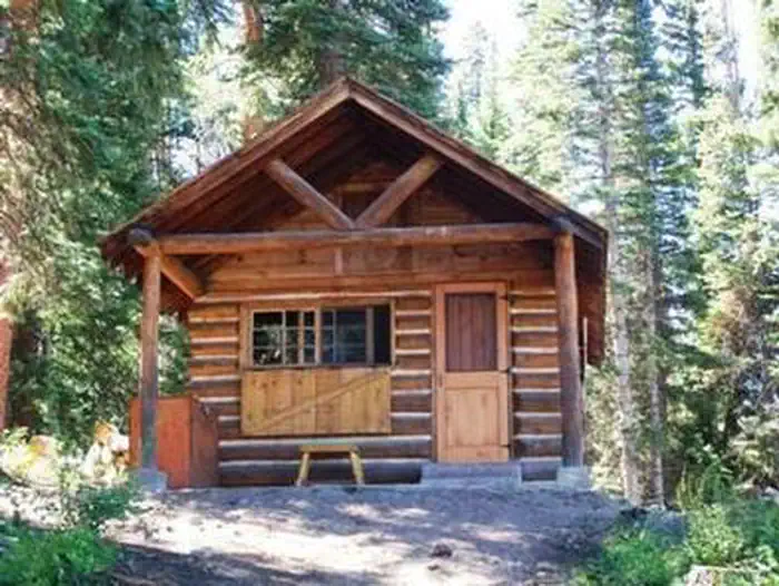 Piney Guard Station β The front of a wooden cabin in a forest