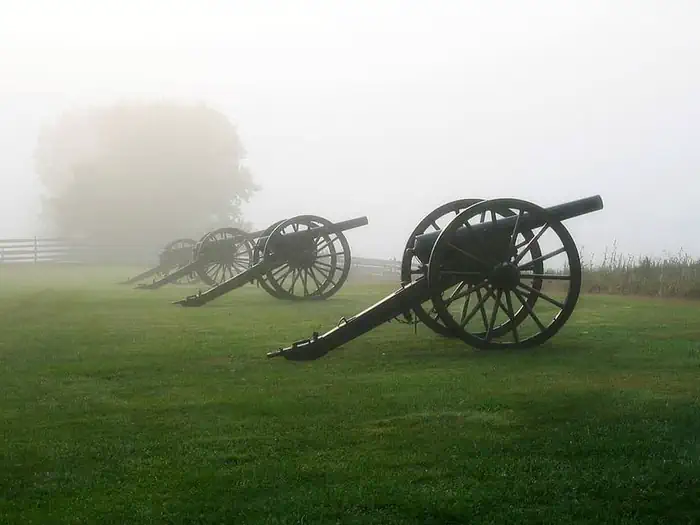 Rohrbach Group Campground — Four civil war cannons along a green foggy field.