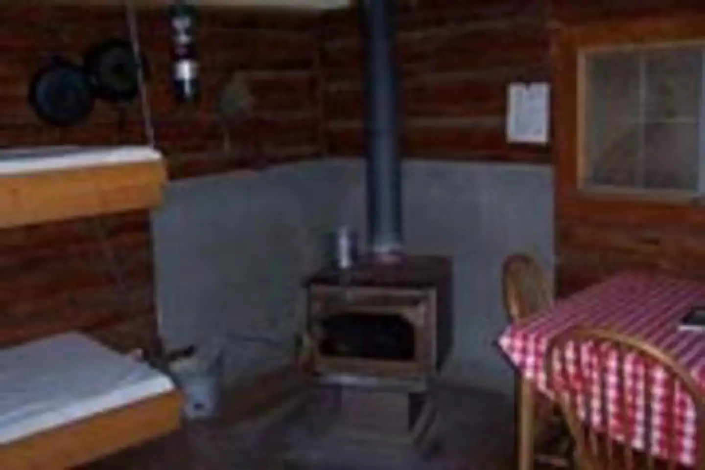 Indian Flats Cabin — Wood burning stove and dining table inside the cabin
