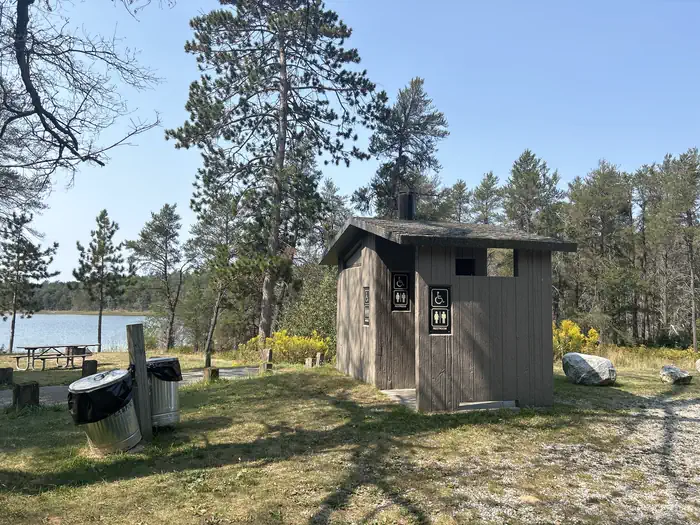 Wagner Lake Campground — A photo of a vault toilet and trash receptacle at Wagner Lake (MI)