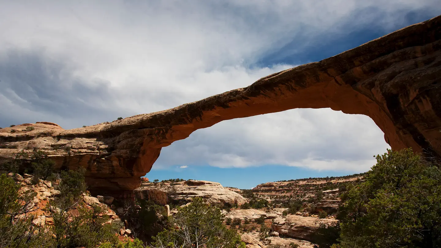 Natural Bridges Campground — Owachomo Natural Bridge under a blue sky and cumulus clouds