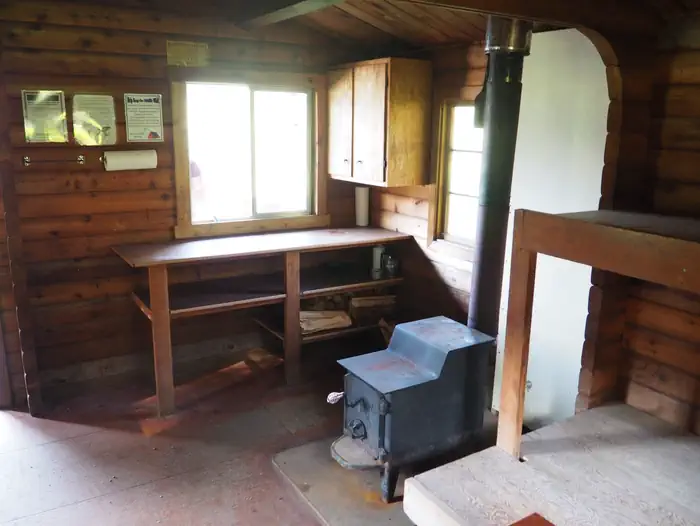 Marten Lake Cabin β Marten Lake Cabin wood interior with stove and shelves