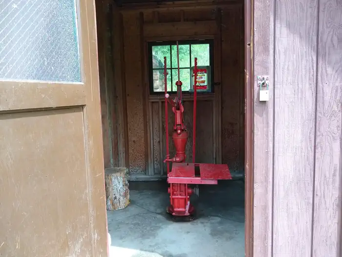 Deer Park Cabin β A water pump in a wooden pump house.