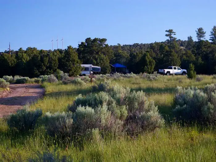 Arch Dam Campground — Truck, tent trailer and pop-up canopy in a campsite.