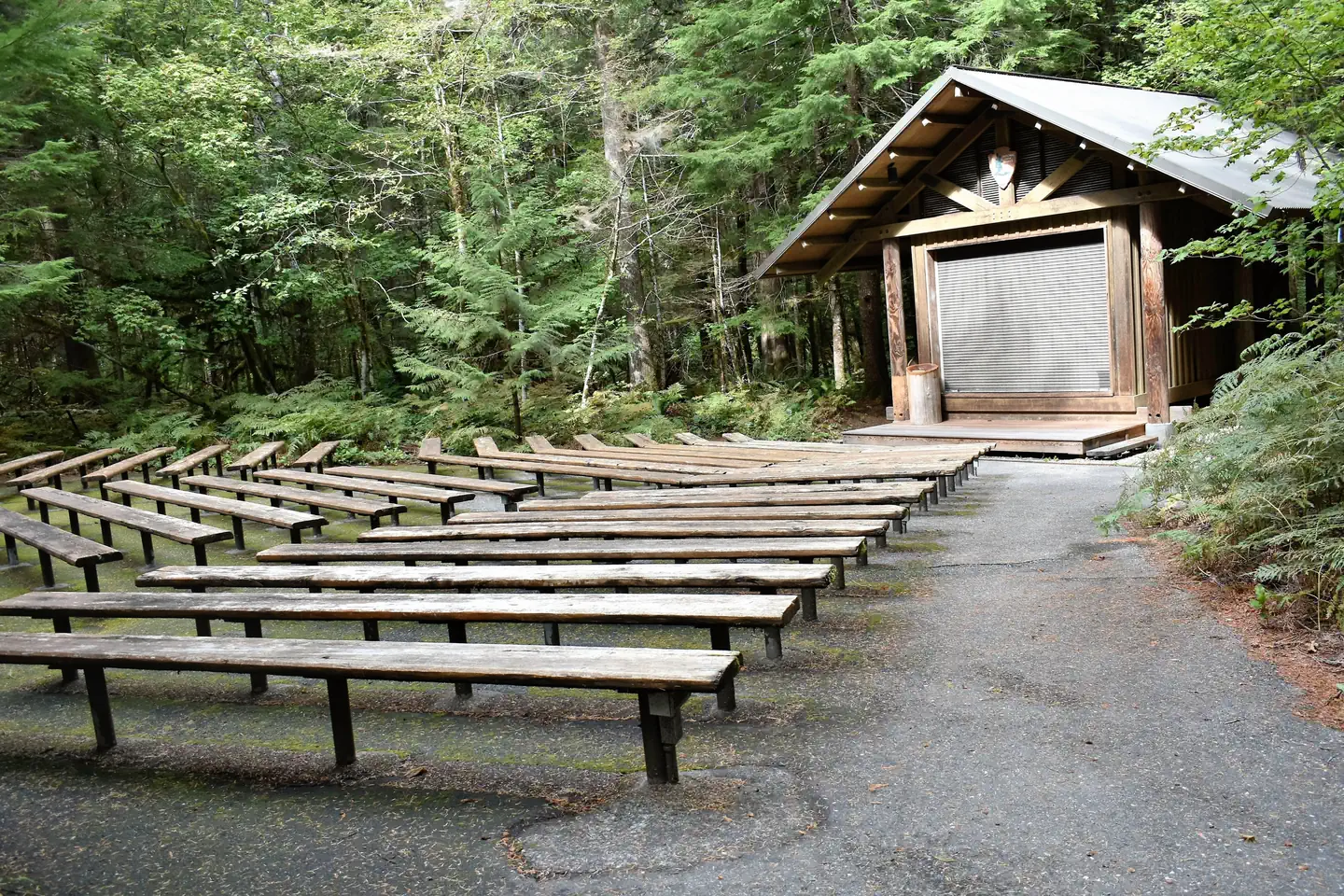 Newhalem Creek Campground — Rustic amphitheater in campground with benches and a building with a stage. 