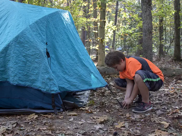 OAK RIDGE CAMPGROUND — A young man sets up a blue tent