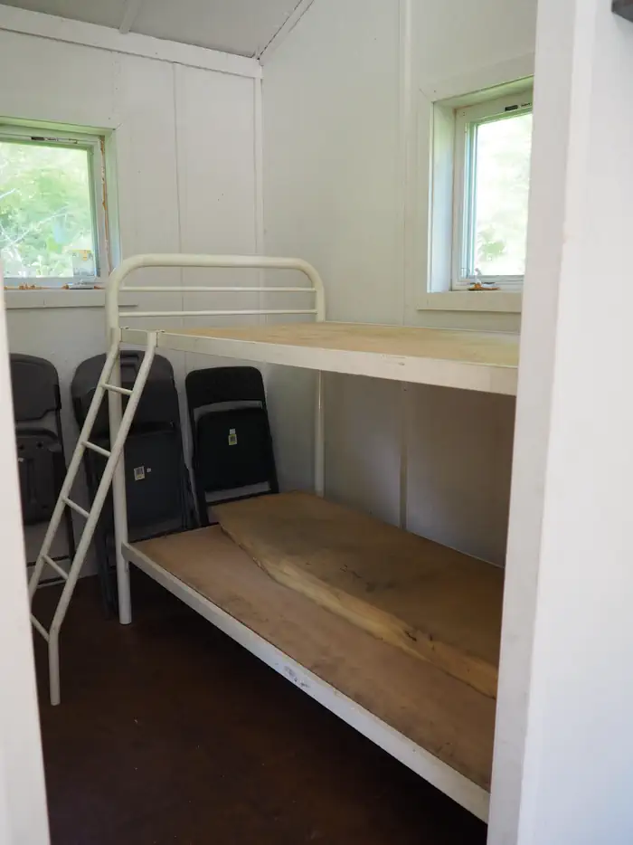 Deep Bay Cabin — Deep Bay Cabin metal bunks with folding chairs
