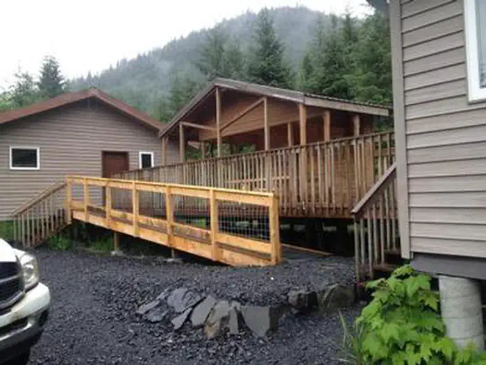 Deep Bay Cabin — Deep Bay Cabin exterior with accessible ramp to the porch and gravel driveway in foreground