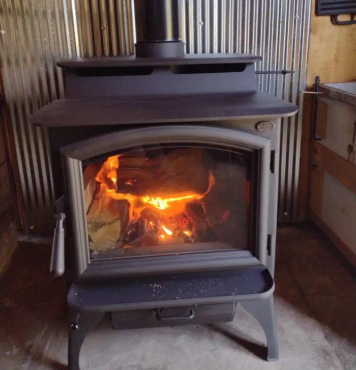 WEST FORK CABIN (W OF CHOTEAU) — Wood stove with fire burning inside