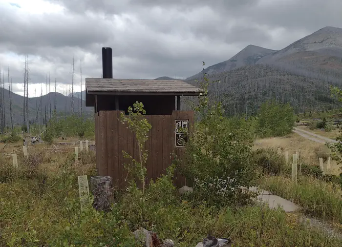 WEST FORK CABIN (W OF CHOTEAU) — Outhouse on cloudy day with mountain in background