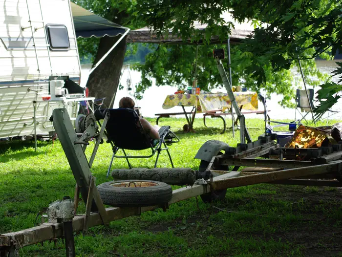 Blanchard Island Recreation Area — Camper looking out over the river from lawn chair and trailer