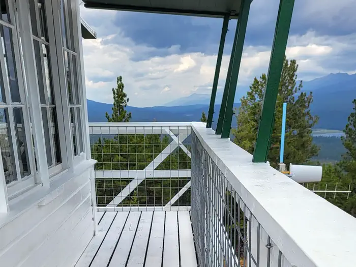 Double Arrow Lookout β Double Arrow Lookout Tower- Exterior deck facing North to Seeley Lake water body and Richmond Ridge Mountains. Cotton Candy colored clouds during sunset.